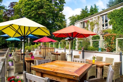a group of tables with umbrellas on a patio at Banchory Lodge Hotel in Banchory