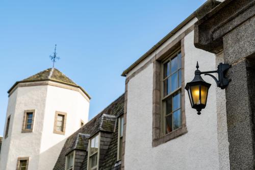 a street light on the side of a building with a tower at Banchory Lodge Hotel in Banchory