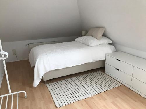 una piccola camera con un letto bianco e una cassettiera bianca di Ferienwohnung Haus Heimes a Nettetal
