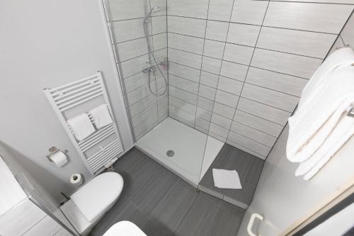a small bathroom with a toilet and a shower at Hotel Mecklenheide in Hannover