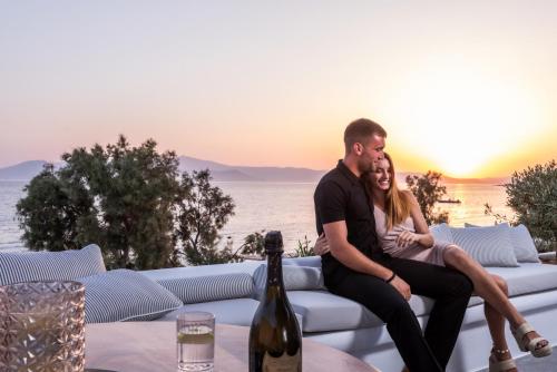 a man and woman sitting on a couch watching the sunset at Santana Beach in Agia Anna Naxos