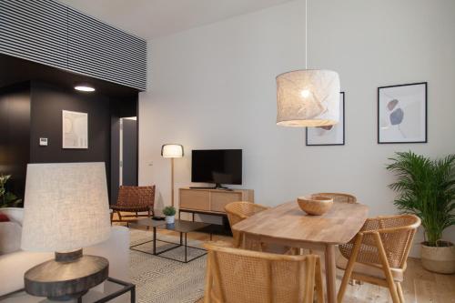 uma sala de estar com uma mesa e cadeiras e uma televisão em FLH Praça Comércio Bright Flat em Lisboa