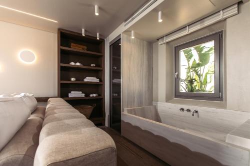 a large bathroom with a large tub and a window at Santana Beach in Agia Anna Naxos