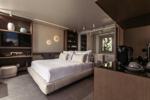 a bedroom with a large white bed and a kitchen at Santana Beach in Agia Anna Naxos
