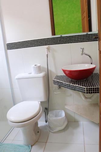 a bathroom with a toilet and a sink at CHALÉS e SUITES PORTO SEGURO in Maresias