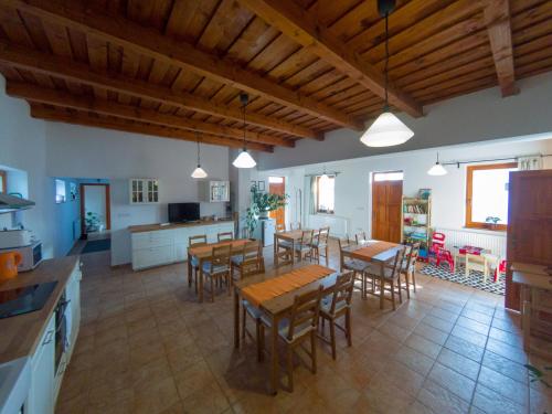a large kitchen and dining room with wooden tables and chairs at Kun Pista Vendégház in Vértesboglár