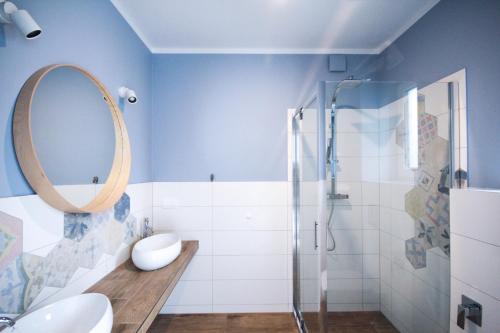 a bathroom with a shower and a sink and a mirror at Apartamenty Skarpa in Mysłakowice