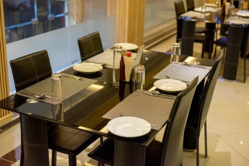 a black table with chairs and plates on it at Euro Hotel and Apartments in Dar es Salaam