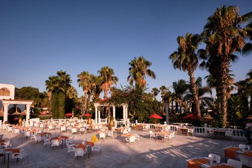 a group of tables and chairs and palm trees at Club Hotel Sera in Antalya