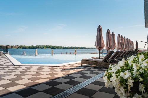 a swimming pool with chairs and umbrellas on a resort at Спа-Готель Потоки Хауз in Kam”yani Potoky