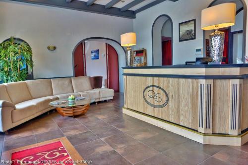 a lobby with a couch and a reception desk at Queen Serenity Hotel in Redon
