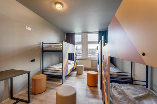 a room with two bunk beds and a table at a&o Hamburg Hauptbahnhof in Hamburg
