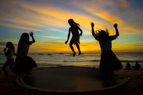 a group of girls jumping on a trampoline on the beach at Franky Villa in Boracay