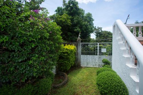 a garden with a white gate and bushes at Franky Villa in Boracay