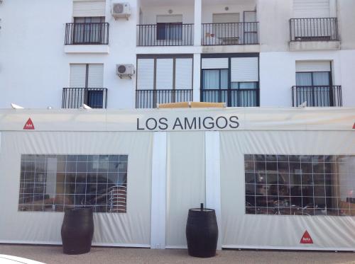 a white building with a los amigos sign on it at Hostal Los Amigos in Olivenza
