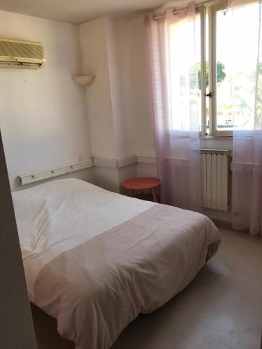 una camera da letto con un letto bianco e una finestra di Bora a Béziers