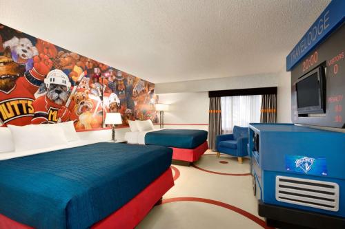 a hotel room with two beds and a football mural at Travelodge Hotel by Wyndham Saskatoon in Saskatoon