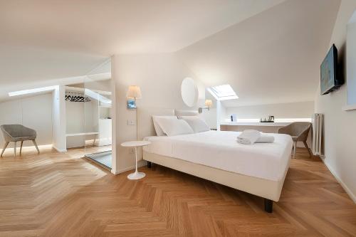 biała sypialnia z łóżkiem i lustrem w obiekcie Asisium Boutique Hotel w Asyżu