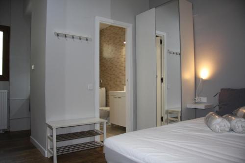 a bedroom with a white bed and a mirror at Vielha centro estudio Sapporo in Vielha