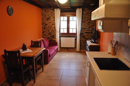 a kitchen with a couch and a table in a room at APARTAMENTOS RURALES CASTRO DE VILAOSENDE in Ribadeo