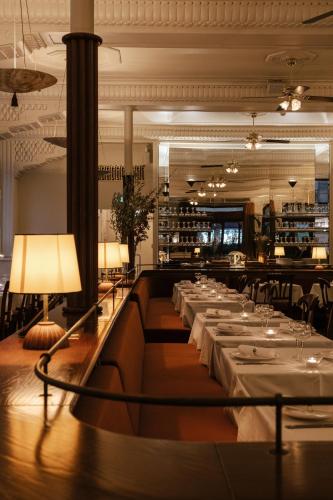 a dining room with tables and chairs and lamps at Hotel Rochechouart - Orso Hotels in Paris