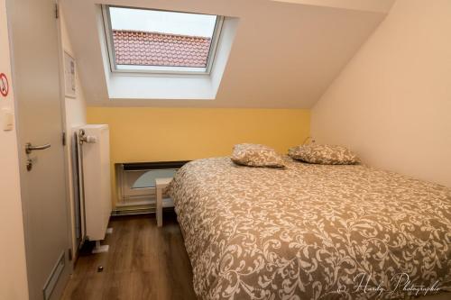 1 dormitorio con cama y ventana en Les gîtes du Broukay - Alouette, en Bassenge