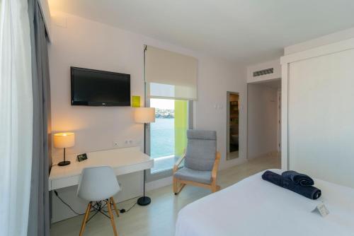 a living room with a television and a desk at ARTIEM Carlos - Adults Only in Es Castell