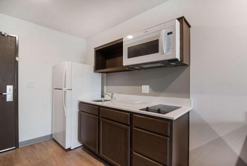 a kitchen with a sink and a white refrigerator at WoodSpring Suites Fort Mill in Fort Mill