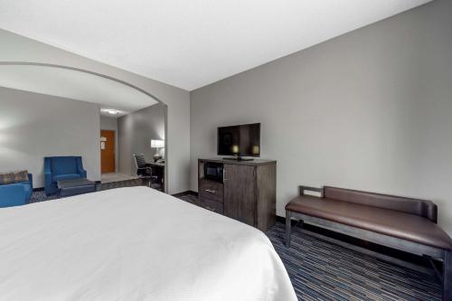 a bedroom with a bed and a desk and a tv at Garner Hotel Oklahoma City - Quail Springs by IHG in Oklahoma City
