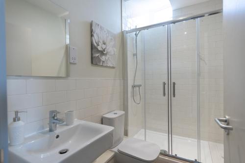 Apartment 6, Isabella House, Aparthotel, By RentMyHouse في هيريفورد: حمام مع دش ومغسلة ومرحاض