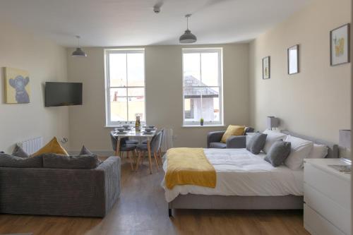 Apartment 6, Isabella House, Aparthotel, By RentMyHouse في هيريفورد: غرفة نوم بسرير واريكة وطاولة