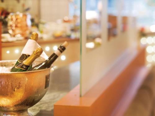 two bottles of champagne in a bucket on a counter at Mövenpick Hotel München-Airport in Hallbergmoos
