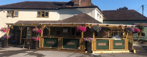 a store with flowers on the front of a building at Greyhound Inn in Winterborne Kingston