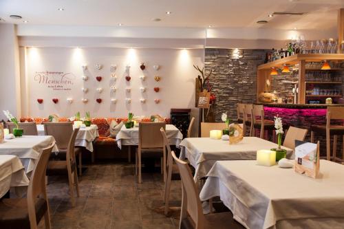 a dining room with white tables and chairs and a wall at Am Dorfplatz Suites - Adults friendly in Sankt Anton am Arlberg