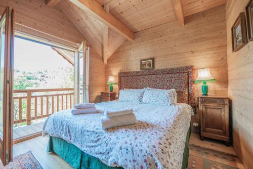 圣沙夫雷Chalet Hibou, large chalet with mountain views and close to slopes的一间带床和大窗户的卧室