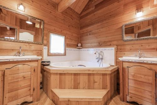 圣沙夫雷Chalet Hibou, large chalet with mountain views and close to slopes的木制浴室设有浴缸和两个盥洗盆