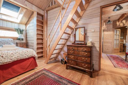 a bedroom in a log cabin with a bed and a mirror at Chalet Hibou, large chalet with mountain views and close to slopes in Saint-Chaffrey