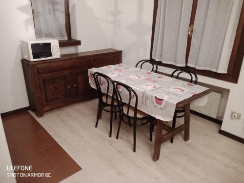 a dining room table with chairs and a microwave at Jackson in Sauze di Cesana