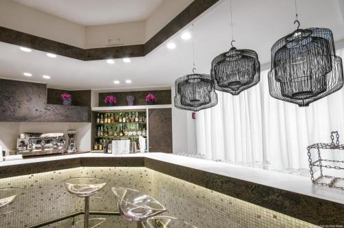 a bar with two chairs and two chandeliers at Hotel Excelsior San Marco in Bergamo