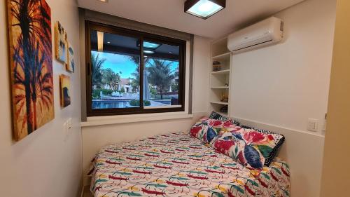 a small bedroom with a bed and a window at Malawi Muro Alto - Flat 103H Térreo in Porto De Galinhas