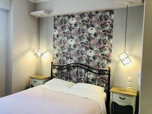 sypialnia z łóżkiem i tapetą w kwiaty w obiekcie Lovely Apartments w mieście Patras