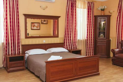 a bedroom with a bed and a mirror and a chair at Korona Hotel in Boryspilʼ