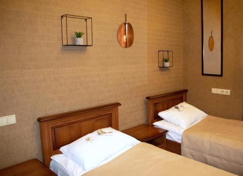 um quarto com duas camas e duas plantas na parede em Bogdanov Yar Hotel em Kiev