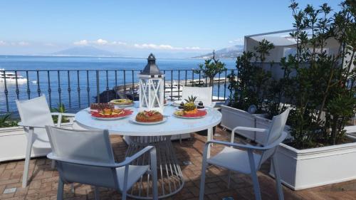a patio with a table and chairs and the ocean at Relais Maresca Luxury Small Hotel & Terrace Restaurant in Capri