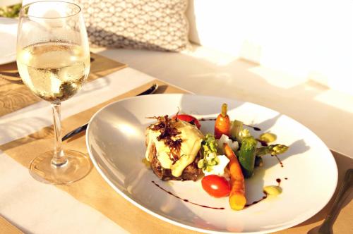 a plate of food and a glass of wine on a table at Zeus Village Resort - Adults Only in Kato Daratso