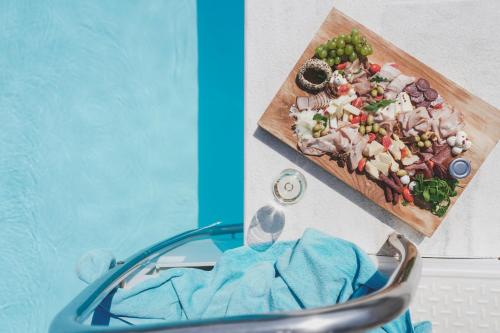 a plate of food on a cutting board on a table at Zeus Village Resort - Adults Only in Kato Daratso