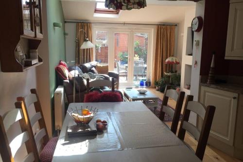 a dining room and living room with a table and chairs at Potters Court A Hidden Gem in Tewkesbury