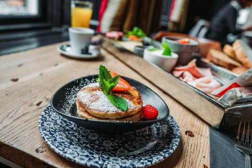 un plato de tortitas con fresas y menta en una mesa en Boutiquehotel 't Gerecht, en Heerenveen