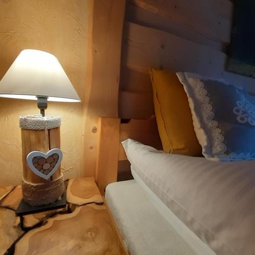 a lamp on a table next to a bed at Staro Chałpa in Istebna
