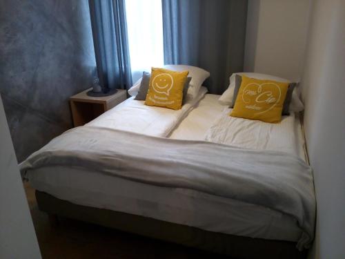a small bed with two yellow pillows on it at Dworek Zakopane in Zakopane